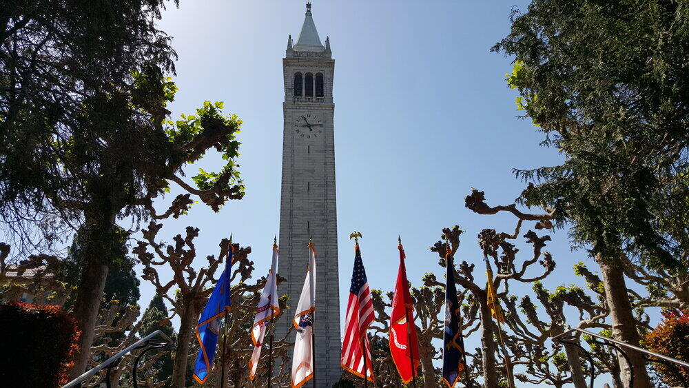 military flags in front of Sather Tower